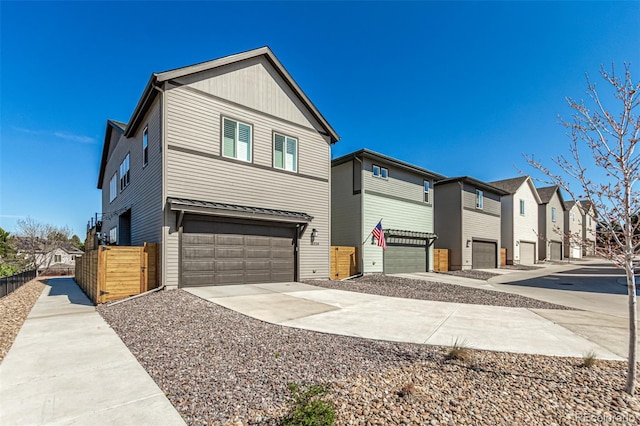exterior space with driveway, fence, a garage, and a residential view