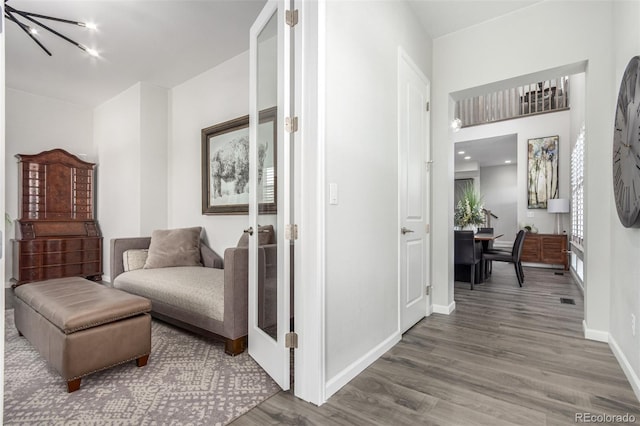 interior space featuring an inviting chandelier, baseboards, visible vents, and wood finished floors