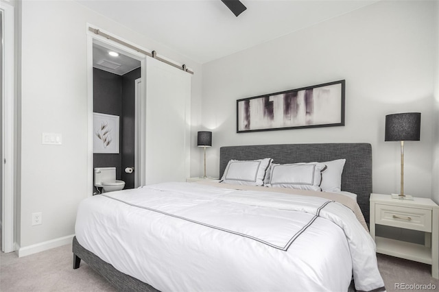 carpeted bedroom featuring a ceiling fan, a barn door, and baseboards