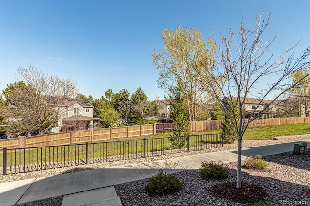 view of yard with a fenced backyard, a patio, and a residential view
