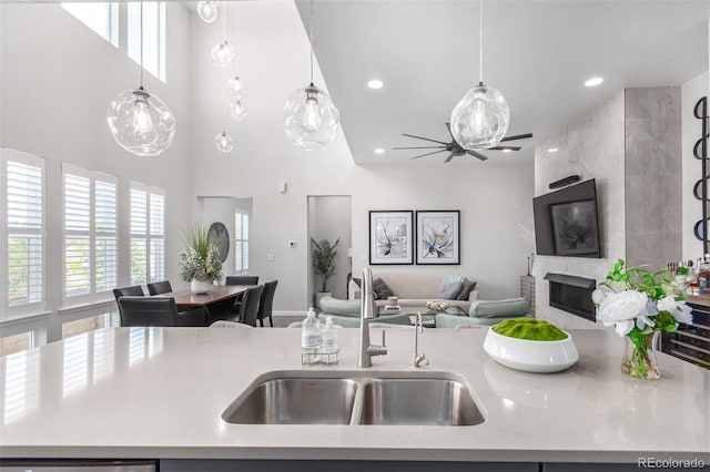 10524 Eby Cir, Lone Tree, CO 80124 - kitchen with open floor plan, a tiled fireplace, pendant lighting, recessed lighting, and a high ceiling