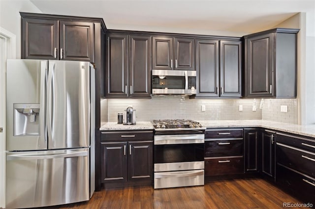 335 Mountain Brush, Colorado Springs, CO 80921 - kitchen with stainless steel appliances, light stone countertops, tasteful backsplash, and dark wood-type flooring