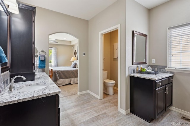 335 Mountain Brush, Colorado Springs, CO 80921 - ensuite bathroom featuring two vanities, toilet, wood finished floors, and baseboards