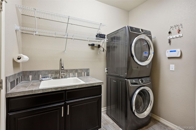 335 Mountain Brush, Colorado Springs, CO 80921 - laundry area featuring estacked washer and dryer, cabinet space, and baseboards