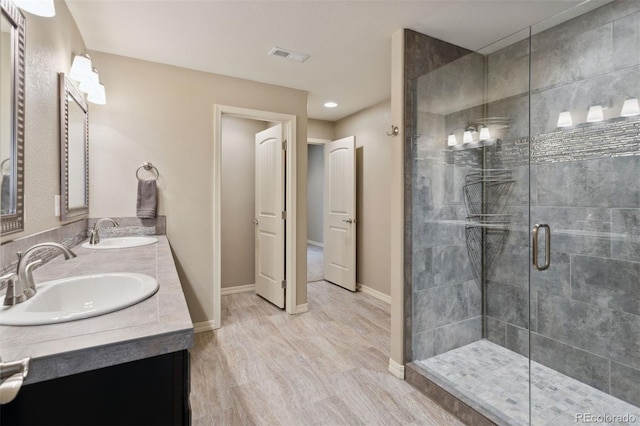 335 Mountain Brush, Colorado Springs, CO 80921 - bathroom with double vanity, a shower stall, wood finished floors, and baseboards
