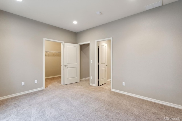 335 Mountain Brush, Colorado Springs, CO 80921 - unfurnished bedroom featuring a walk in closet, light carpet, baseboards, recessed lighting, and a closet
