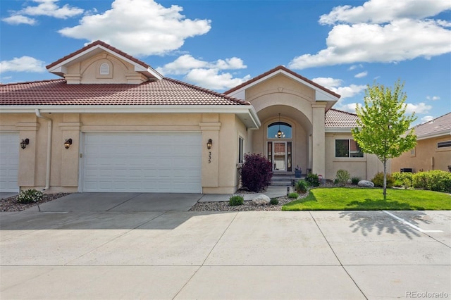 335 Mountain Brush, Colorado Springs, CO 80921 - mediterranean / spanish-style home with driveway, a tile roof, stucco siding, an attached garage, and a front lawn