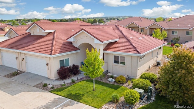 335 Mountain Brush, Colorado Springs, CO 80921 - mediterranean / spanish house featuring a tiled roof, stucco siding, an attached garage, a residential view, and cooling unit