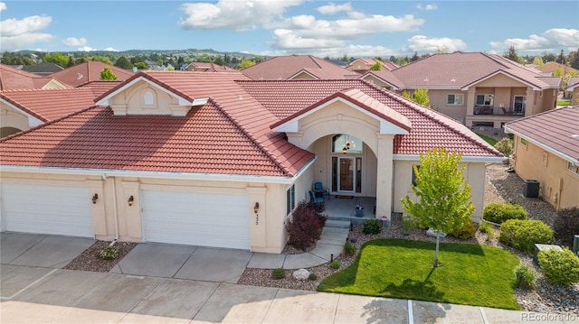335 Mountain Brush, Colorado Springs, CO 80921 - mediterranean / spanish house with a tiled roof, stucco siding, a residential view, concrete driveway, and central AC unit