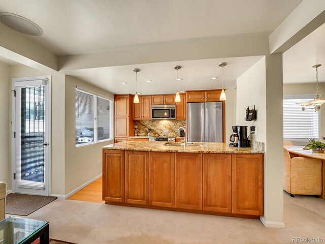 1011 N Pennsylvania St Unit H, Denver, CO 80203 - kitchen with appliances with stainless steel finishes, light colored carpet, a sink, light stone counters, and a peninsula