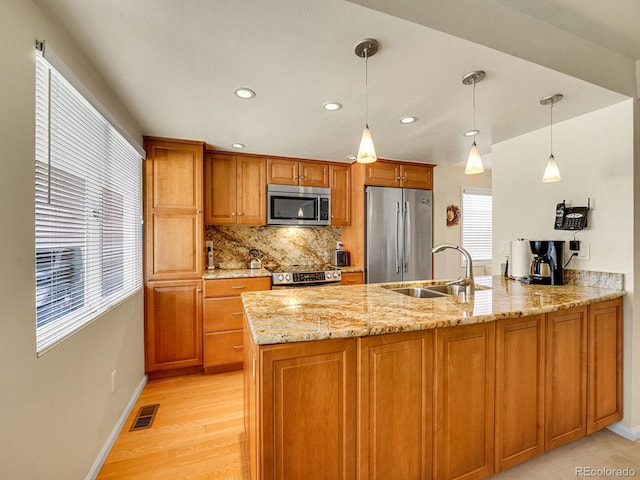 1011 N Pennsylvania St Unit H, Denver, CO 80203 - kitchen with stainless steel appliances, a peninsula, a sink, light stone countertops, and decorative backsplash