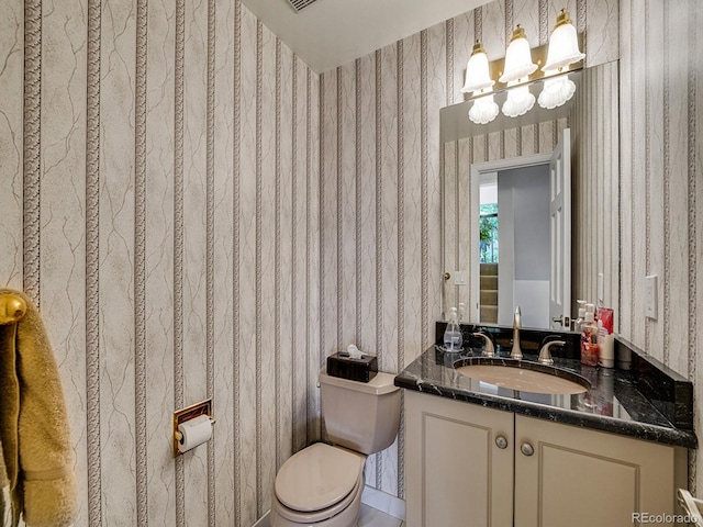 1011 N Pennsylvania St Unit H, Denver, CO 80203 - bathroom featuring wallpapered walls, toilet, vanity, and a chandelier