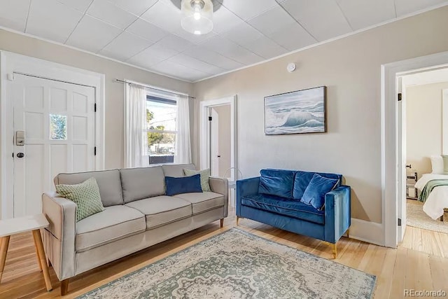 living area with ornamental molding and wood finished floors