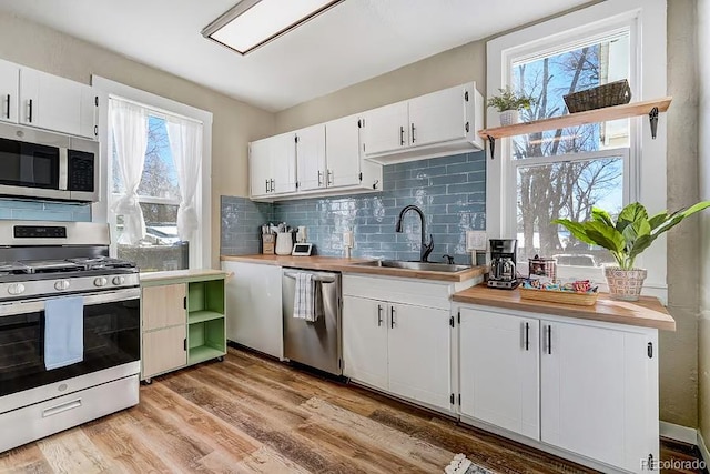 kitchen with plenty of natural light, a sink, tasteful backsplash, and stainless steel appliances