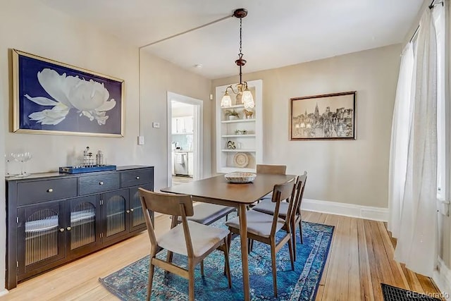 dining room with baseboards, visible vents, and light wood-style flooring