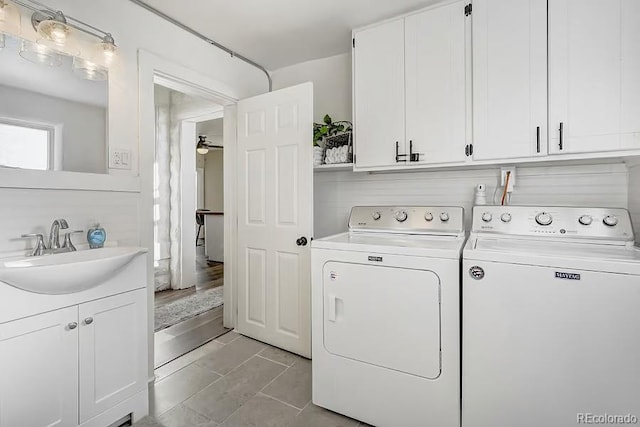 laundry area featuring washing machine and clothes dryer, light tile patterned flooring, cabinet space, a sink, and a ceiling fan