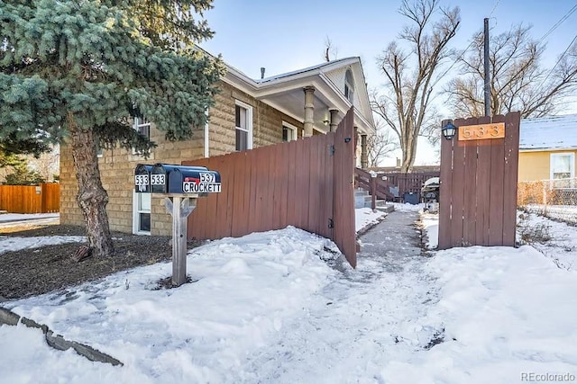 view of snowy exterior with fence