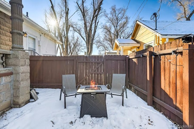 yard layered in snow featuring fence and a fire pit