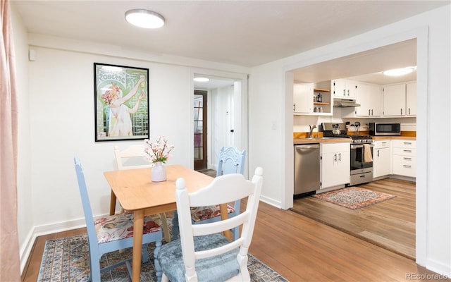 dining space featuring baseboards and light wood finished floors