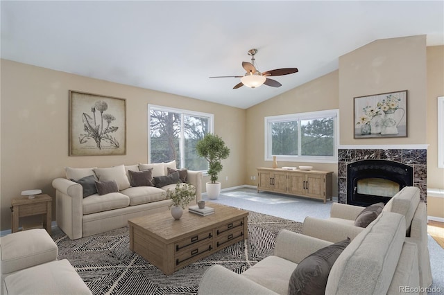 living area with a premium fireplace, ceiling fan, baseboards, and lofted ceiling