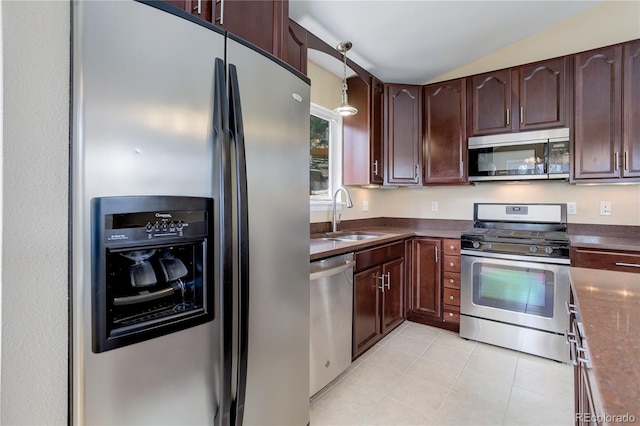 kitchen featuring appliances with stainless steel finishes, dark countertops, dark brown cabinets, a sink, and light tile patterned floors