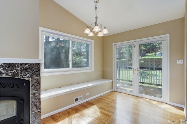 unfurnished dining area with visible vents, plenty of natural light, wood finished floors, and an inviting chandelier
