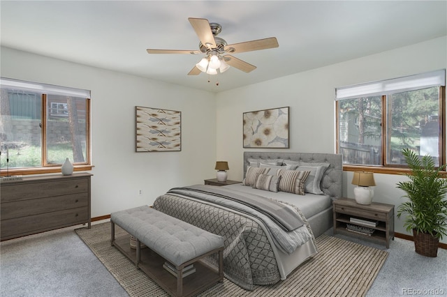 bedroom with carpet floors, multiple windows, baseboards, and a ceiling fan