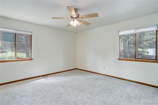 spare room featuring baseboards, visible vents, a wealth of natural light, and carpet