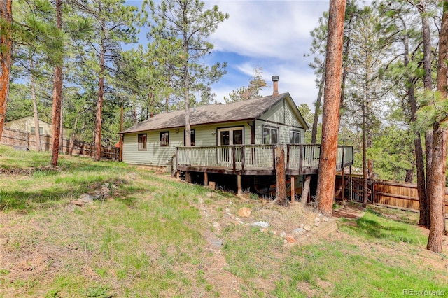 rear view of property featuring a fenced backyard and a wooden deck
