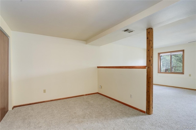 carpeted spare room with baseboards and visible vents