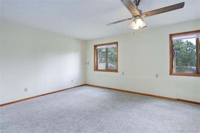 spare room with carpet floors, a ceiling fan, and baseboards