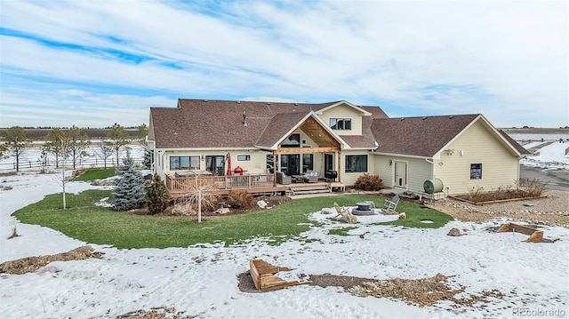 view of front of home featuring a wooden deck, a lawn, and an outdoor fire pit