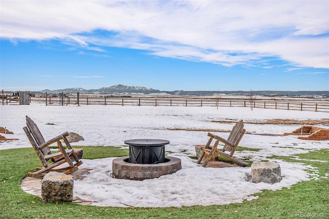 view of yard with an outdoor fire pit, a mountain view, and a rural view