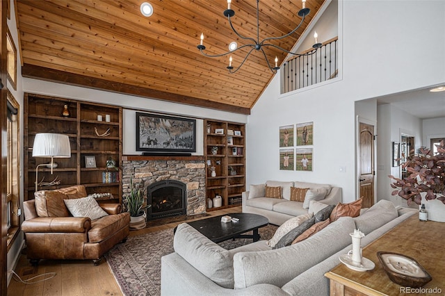 living room with a stone fireplace, built in features, a chandelier, hardwood / wood-style flooring, and wood ceiling