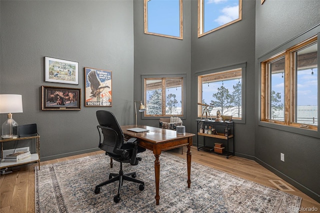 office space featuring a high ceiling and light wood-type flooring