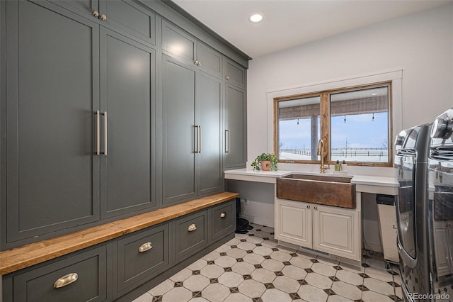 mudroom featuring built in desk, sink, and washing machine and dryer