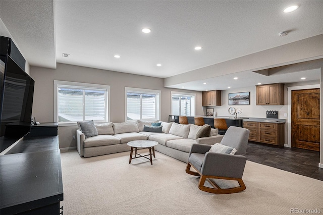 living room featuring a textured ceiling and dark colored carpet