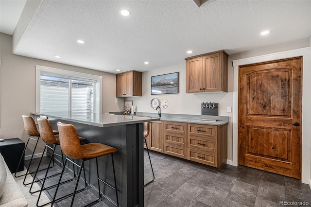 kitchen featuring a center island, a breakfast bar area, and a textured ceiling