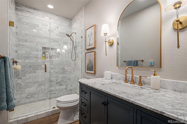 bathroom featuring walk in shower, vanity, toilet, and wood-type flooring