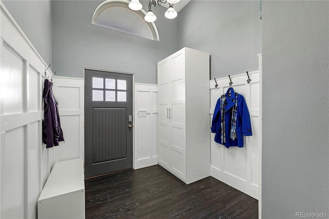 mudroom featuring dark hardwood / wood-style floors, a high ceiling, and an inviting chandelier