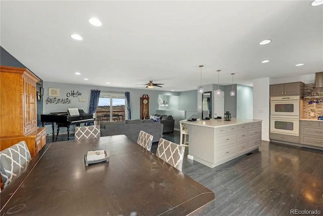 dining space with ceiling fan and dark hardwood / wood-style flooring