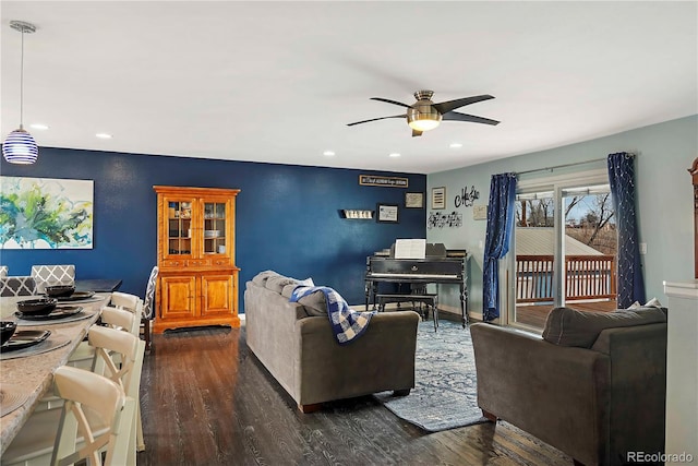 living room featuring ceiling fan and dark wood-type flooring