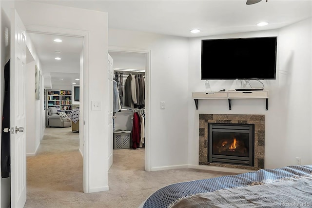 carpeted bedroom with a walk in closet and a closet