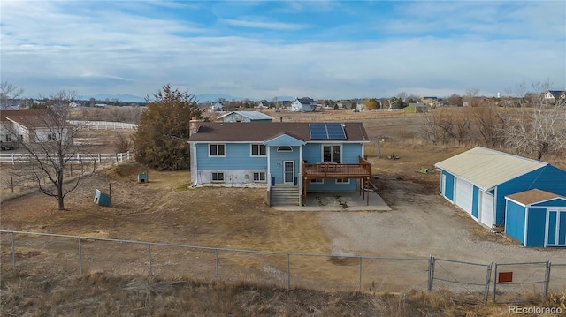 view of front of property with solar panels, an outbuilding, and a deck