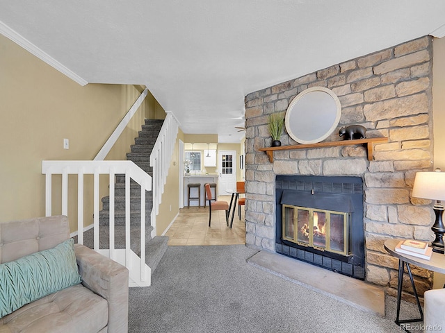 carpeted living room with ornamental molding and a stone fireplace