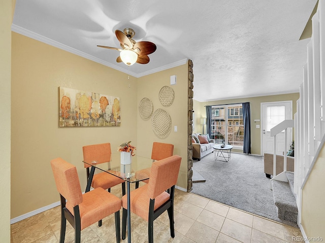 dining space featuring crown molding, light colored carpet, ceiling fan, and a textured ceiling