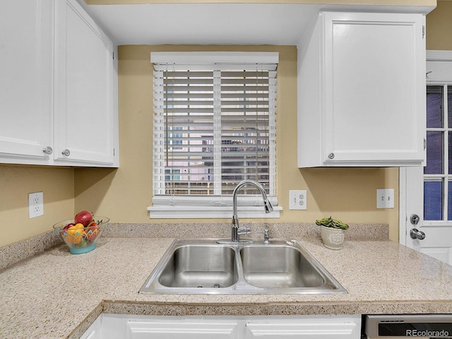 kitchen featuring sink, dishwasher, and white cabinets