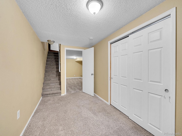 interior space featuring light colored carpet and a textured ceiling