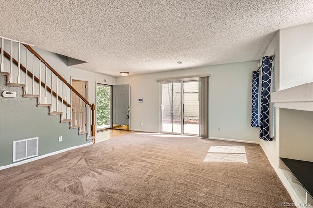 4081 Odessa St, Denver, CO 80249 - unfurnished living room with carpet flooring, stairs, a textured ceiling, and baseboards