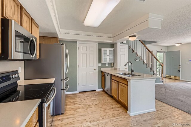 4081 Odessa St, Denver, CO 80249 - kitchen with appliances with stainless steel finishes, a sink, a peninsula, brown cabinetry, and light countertops